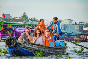một đoàn khách du lịch đi tham quan chợ nổi